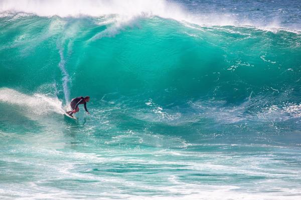 Surfista corriendo una ola