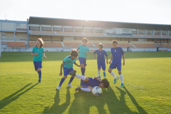 Imagen decorativa, con niños jugando al fútbol sonrientes