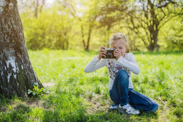 niña tomando fotografía en un parque