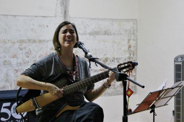 Mujer cantando y tocando la guitarra