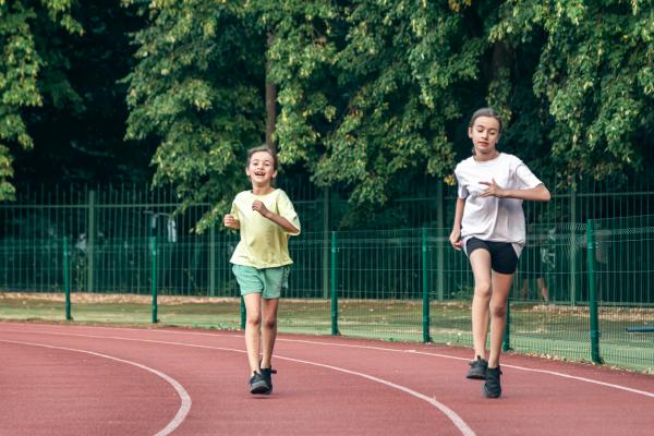 Dos niñas corriendo en pista de atletismo