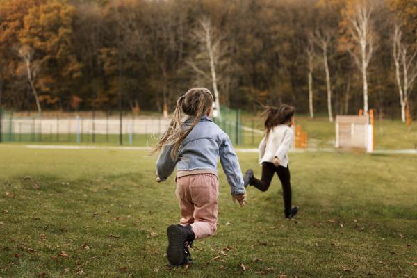 Niños corriendo en un parque agreste.