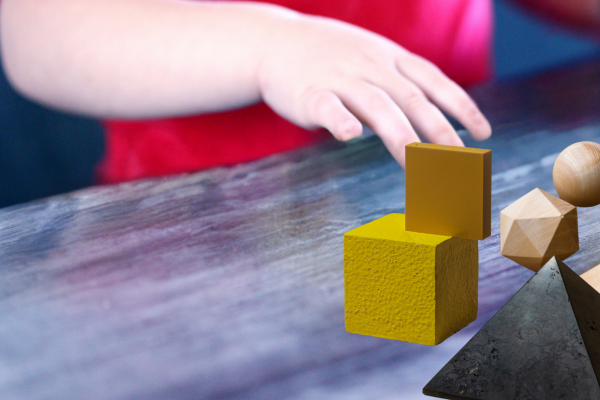 Niño jugando con cuerpos geométricos