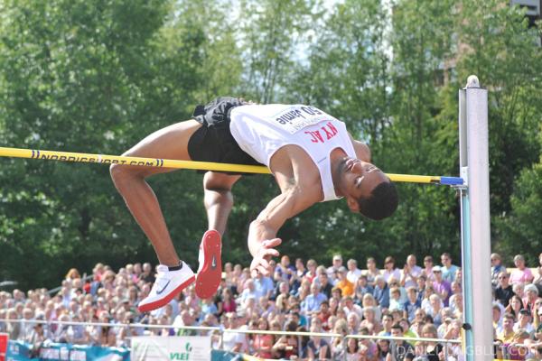 Imagen de un atleta en fase de vuelo del salto sobre un obstáculo.