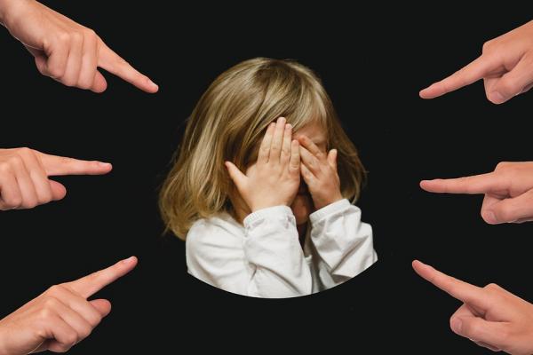 Niña señalada con dedos 