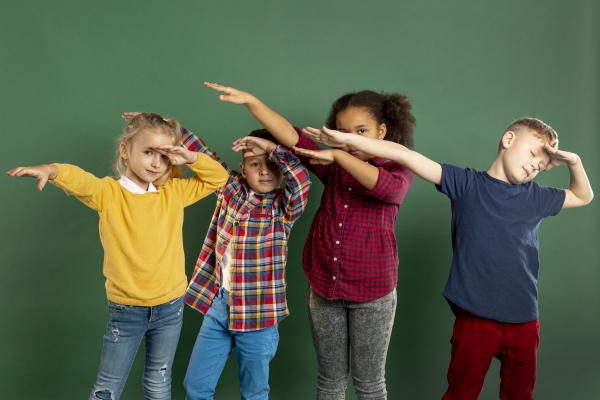 Niños mirando hacia un lado, levantado sus manos 