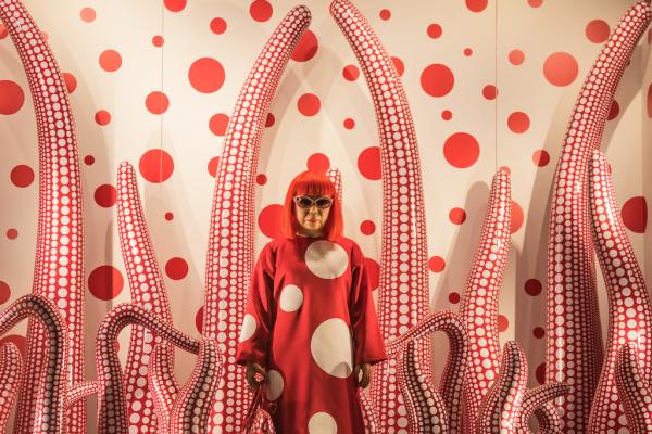 Pintura con lunares rojos alrededor de la artista Yayoi Kusama 