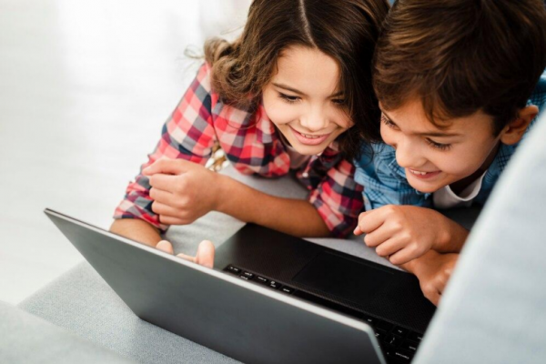 Dos niños mirando una computadora 