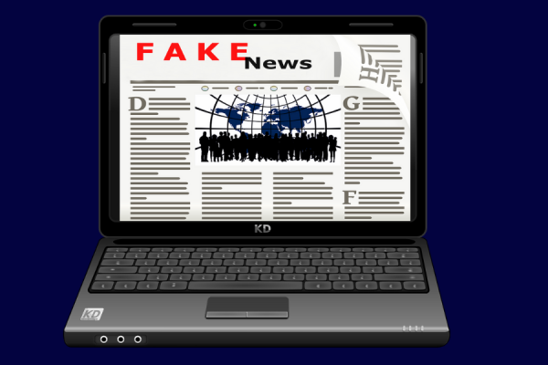 Computadora con un diario ilustrado en la pantalla que dice "Fake news"