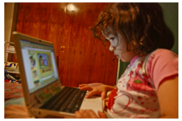 niña pequeña mirando la pantalla de una computadora