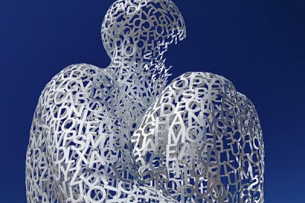 Escultura de ser humano con letras y números