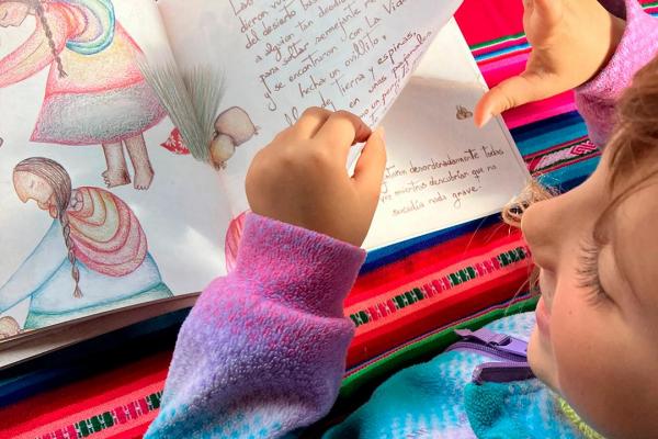 Niña mirando el libro de "Las madres de Los Andes"