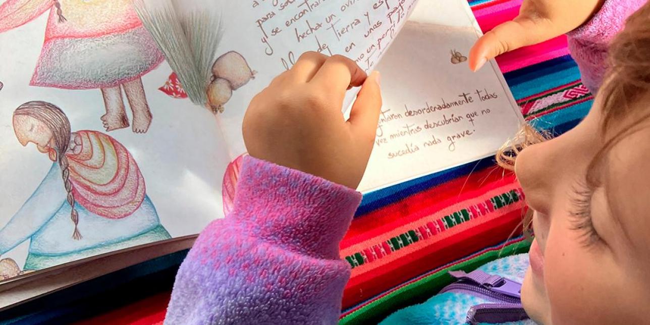 Niña mirando el libro de "Las madres de Los Andes"